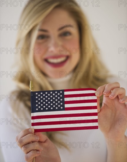 Young woman holding American flag. Photographe : Daniel Grill