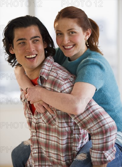 Man giving woman a piggy back ride. Photographe : Daniel Grill