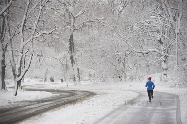 Jogger on snowy road. Photographe : fotog