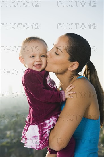 Woman kissing toddler.