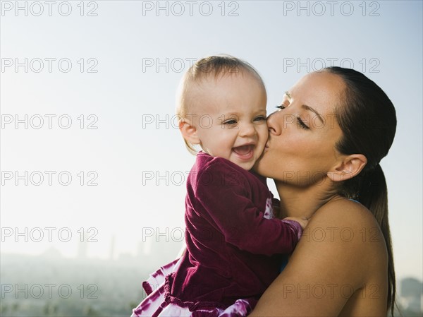 Woman kissing toddler.