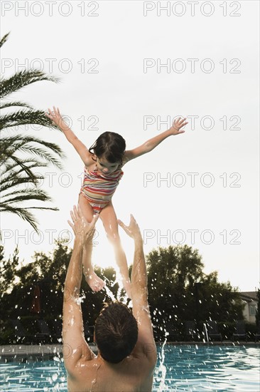 Father and daughter playing in pool.