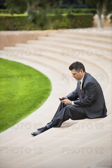 Businessman sitting on steps.