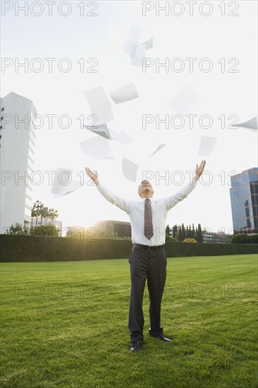 Businessman throwing papers in air.