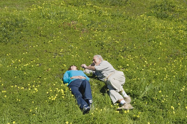 Couple relaxing in meadow.