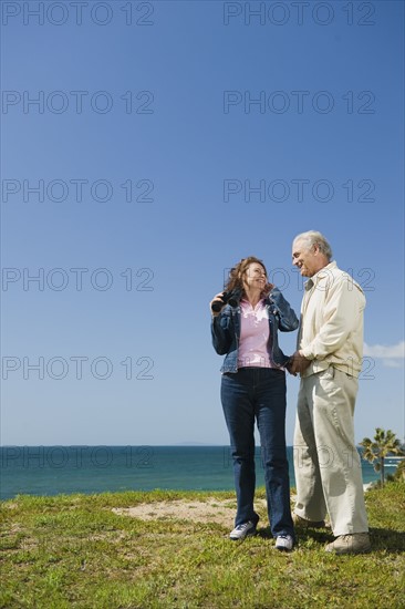 Couple looking at ocean with binoculars.
