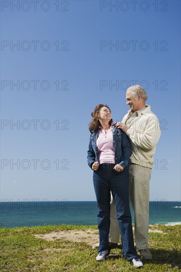 Couple standing near the ocean.