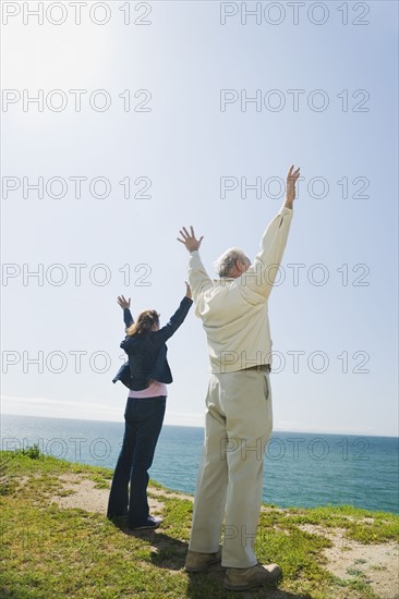 Couple raising their arms.