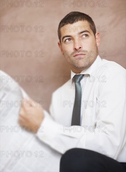 Businessman reading newspaper. Photographe : momentimages