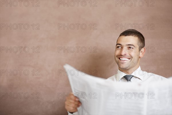 Businessman reading newspaper. Photographe : momentimages