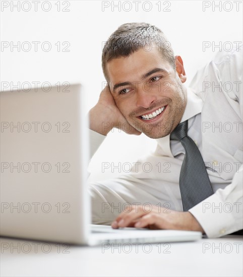 Businessman looking at computer. Photographe : momentimages