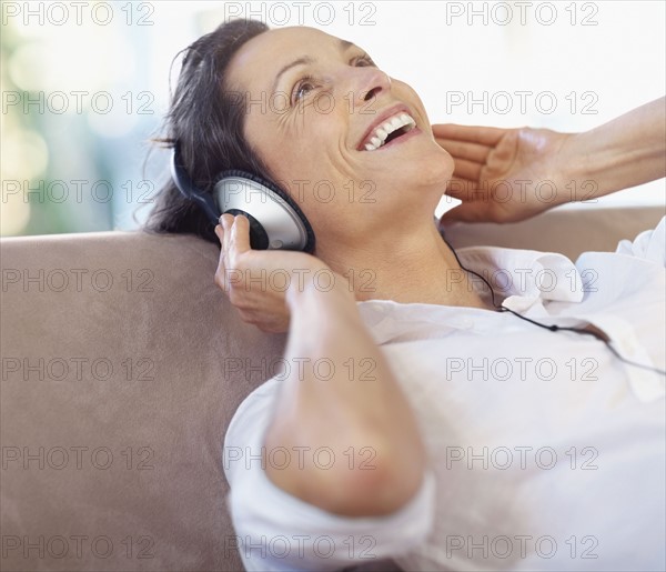 Woman listening to music on headphones. Photographe : momentimages