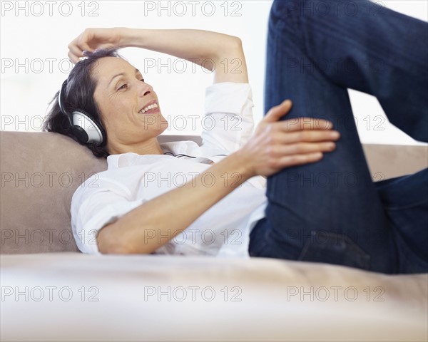 Woman listening to music on headphones. Photographe : momentimages