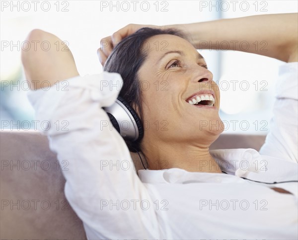 Woman listening to music on headphones. Photographe : momentimages