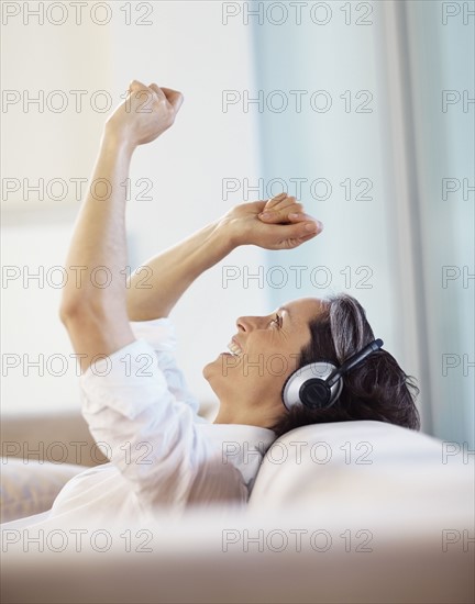 Woman listening to music on headphones. Photographe : momentimages