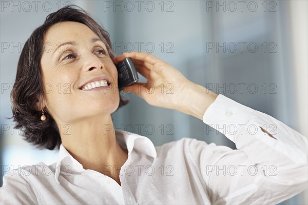 Woman talking on cellular phone. Photographe : momentimages