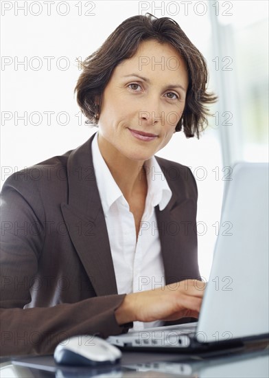 Businesswoman working on laptop. Photographe : momentimages