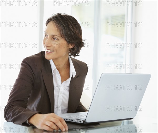 Businesswoman working on laptop. Photographe : momentimages