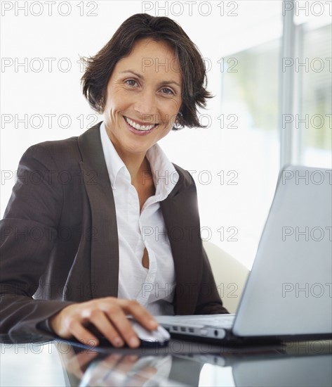 Businesswoman working on laptop. Photographe : momentimages