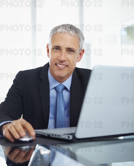 Businessman working on laptop. Photographe : momentimages