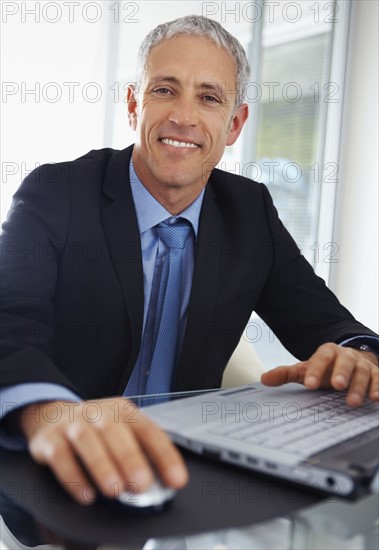 Businessman working on laptop. Photographe : momentimages