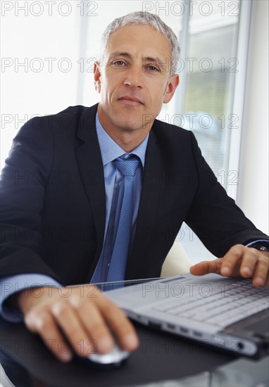 Businessman working on laptop. Photographe : momentimages