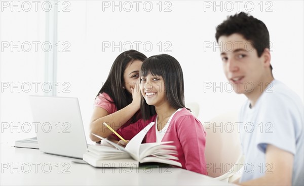 Students whispering classroom. Photographe : momentimages