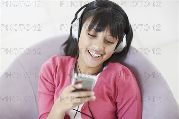 Young girl listening to music. Photographe : momentimages