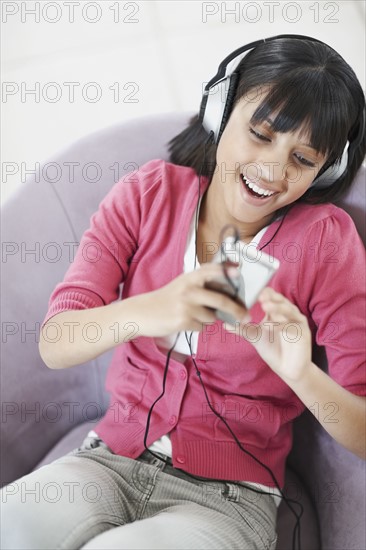 Young girl listening to music. Photographe : momentimages