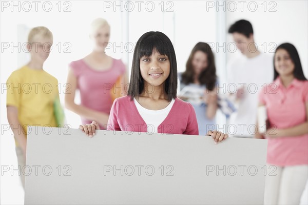 Student holding blank billboard. Photographe : momentimages