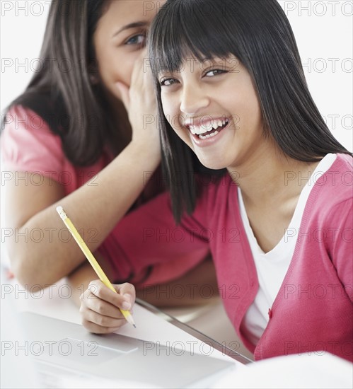 Students whispering in classroom. Photographe : momentimages