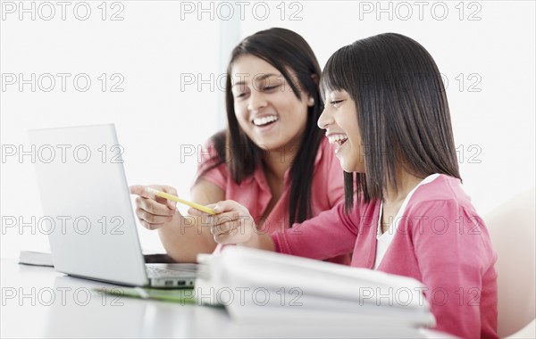 Students looking at laptop. Photographe : momentimages