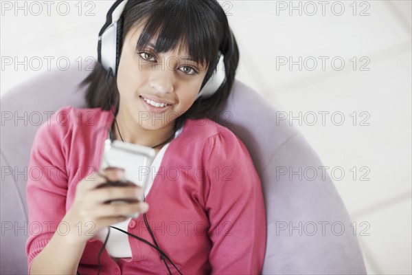 Young girl listening to music. Photographe : momentimages