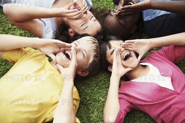 Friends lying in circle on grass. Photographe : momentimages