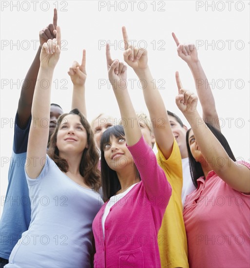 Group of friends pointing up. Photographe : momentimages