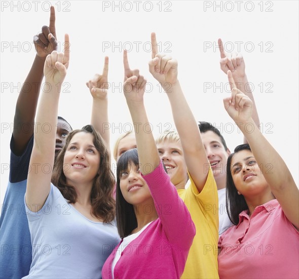 Group of friends pointing up. Photographe : momentimages