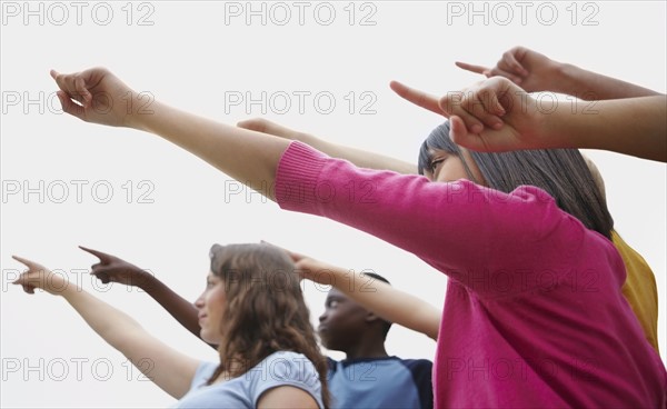 Group of friends pointing. Photographe : momentimages