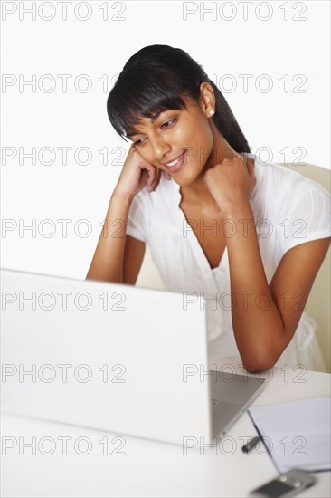 Young woman working at laptop. Photographe : momentimages