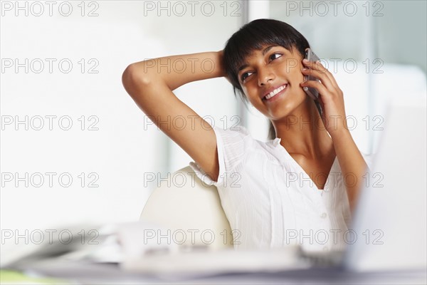 Young girl talking on cellular phone. Photographe : momentimages