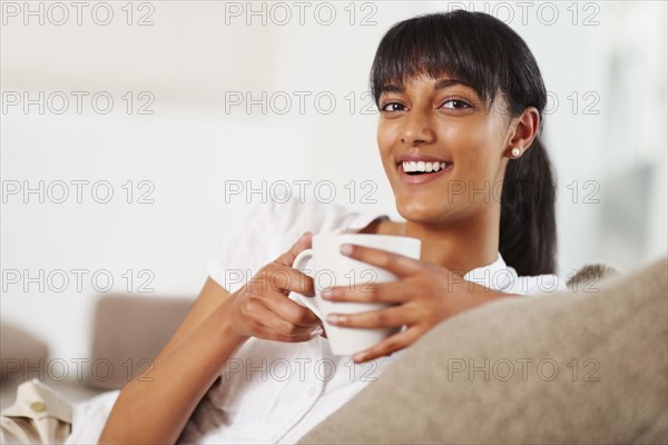 Young woman drinking coffee. Photographe : momentimages