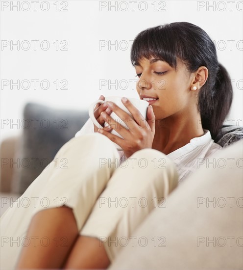 Young woman drinking coffee. Photographe : momentimages