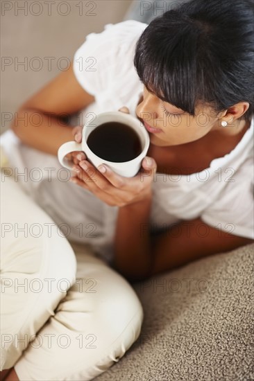 Young woman drinking coffee. Photographe : momentimages