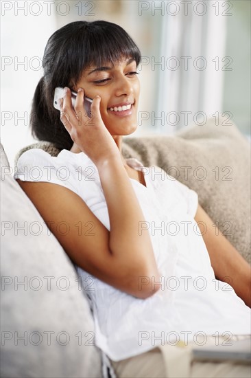 Young woman talking on cellular phone. Photographe : momentimages