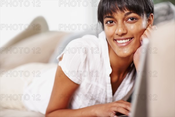 Young woman typing on laptop. Photographe : momentimages