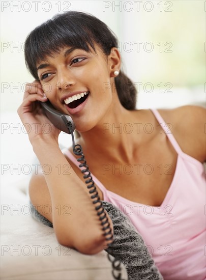Young woman talking on phone. Photographe : momentimages