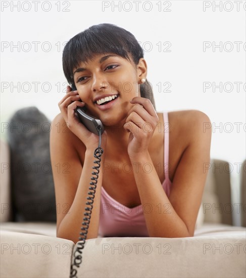 Young woman talking on phone. Photographe : momentimages