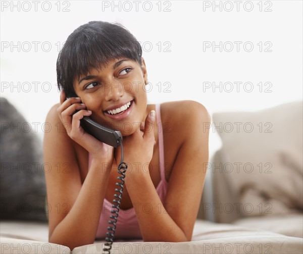 Young woman talking on phone. Photographe : momentimages