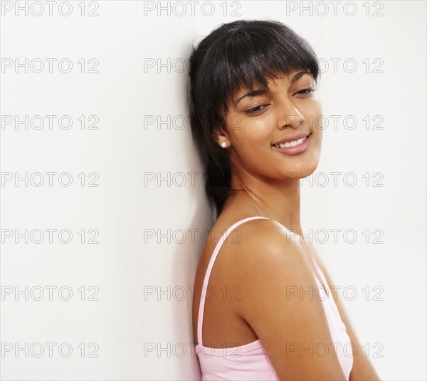 Young woman leaning against wall. Photographe : momentimages