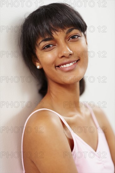 Young woman leaning against wall. Photographe : momentimages