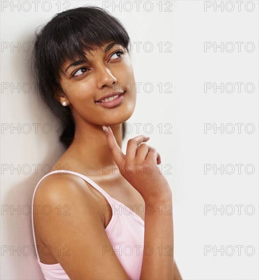 Young woman leaning against wall. Photographe : momentimages